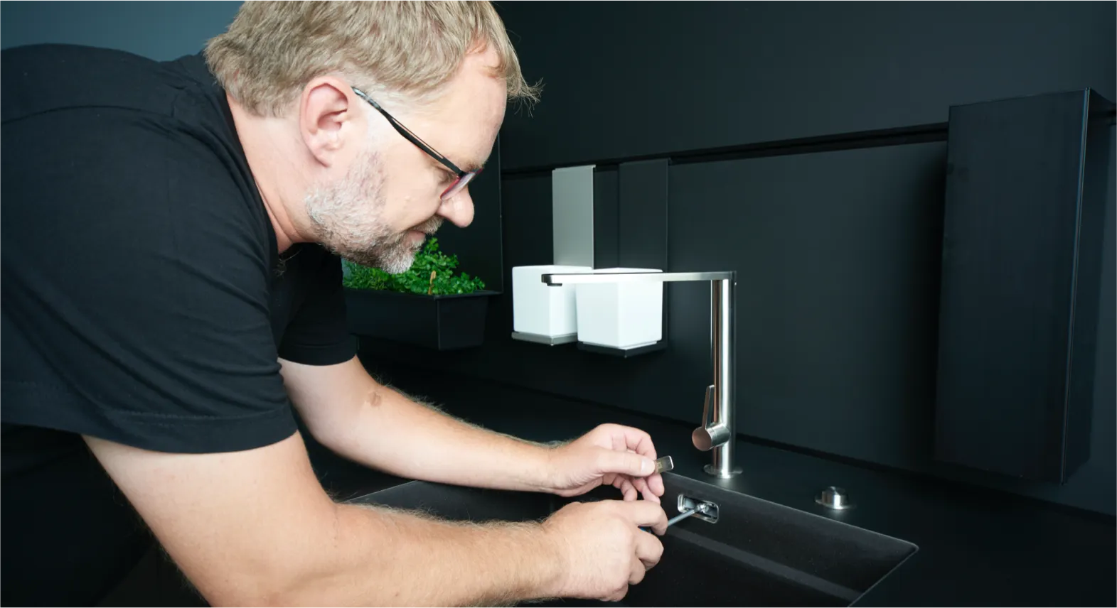 Monteur installiert Wasserhahn in einer Küche