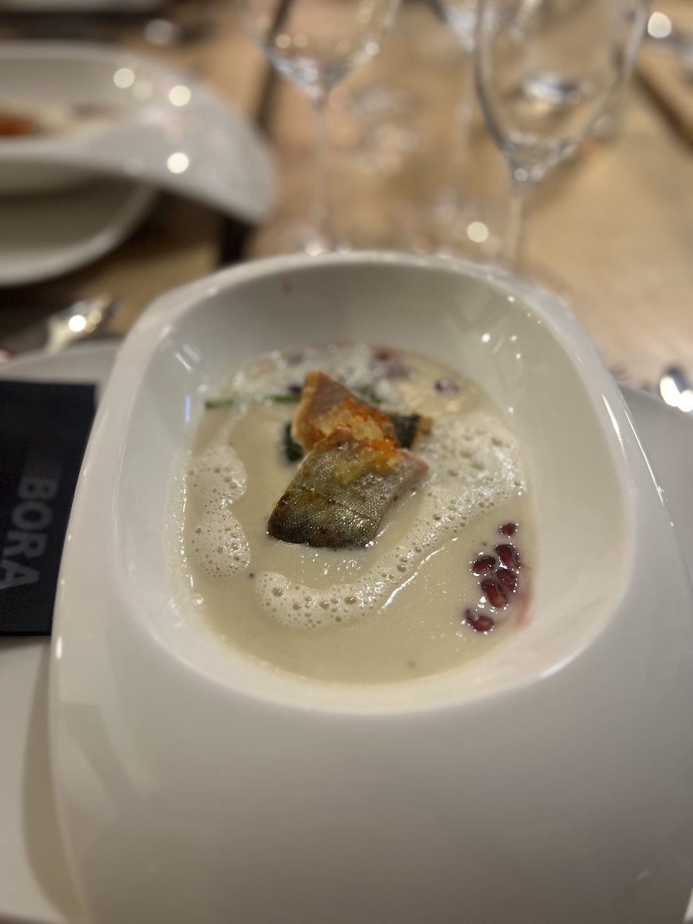 Schön angerichtetes Fischgericht in modernen weißen, tiefen Tellern
