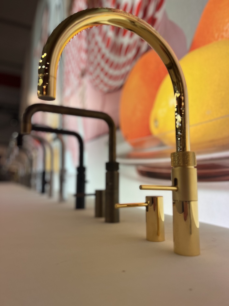 Goldene, gebogene Wasserhähne auf der Messe Küchenmeile
