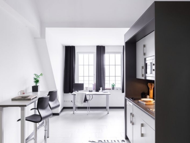 Schwarz-weiße Objektküche mit Sitzecke